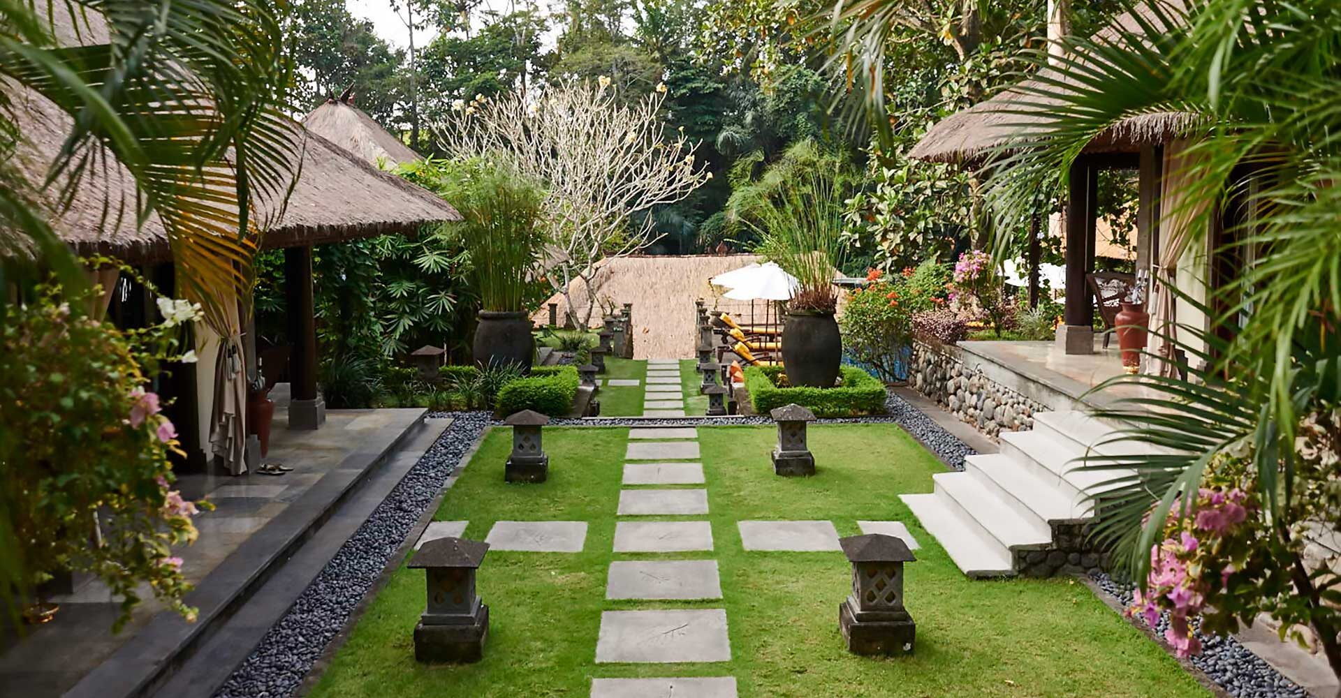 Stone pathway with manicured gardens between two buildings at Sukhavati Bali.