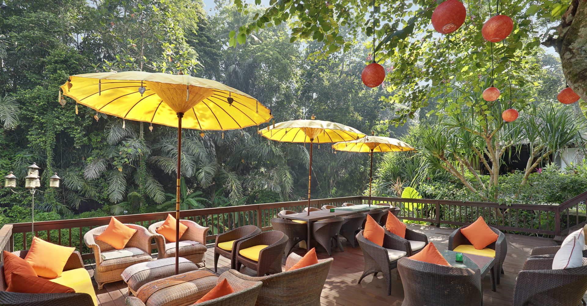 The riverside decking area filled with seats, umbrellas and hanging lanterns.